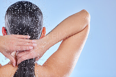 Buy stock photo Shot of a beautiful young woman enjoying a refreshing shower against a blue background