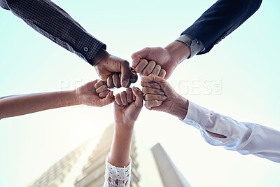 Buy stock photo Below shot of a group of unrecognizable businesspeople joining their hands together in a unity