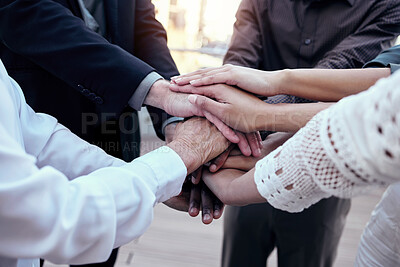 Buy stock photo Shot of a group of unrecognizable businesspeople stacking their hands together outside