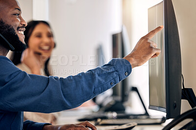 Buy stock photo Shot of a young call centre agent working on a computer with a colleague in an office