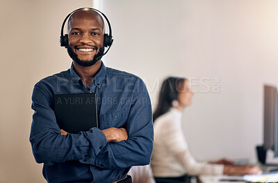 Buy stock photo Portrait of a young call centre agent using a digital tablet while working in an office with his colleague in the background