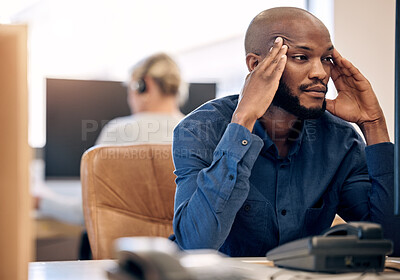 Buy stock photo Shot of a young call centre agent looking stressed out while working on a computer in an office