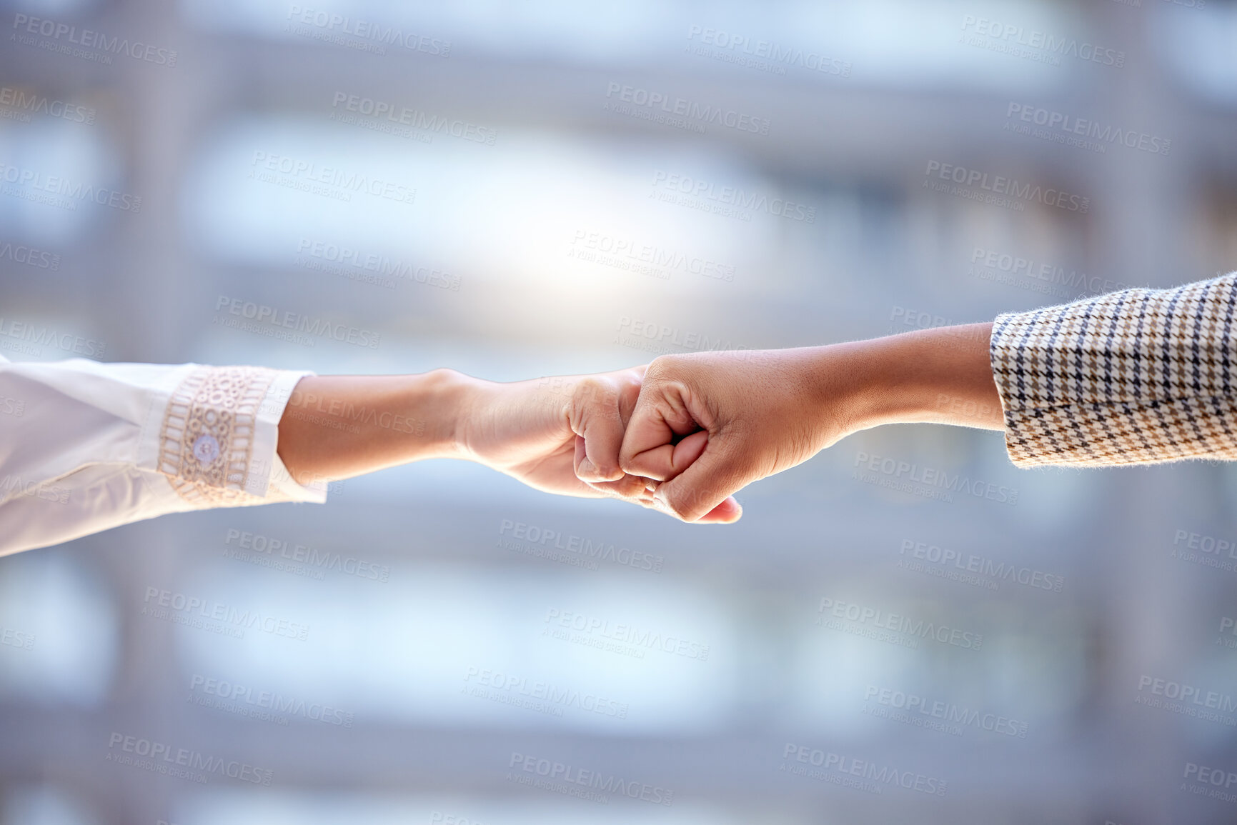 Buy stock photo Shot of two unrecognizable businesspeople giving each other a fist bump against a city background