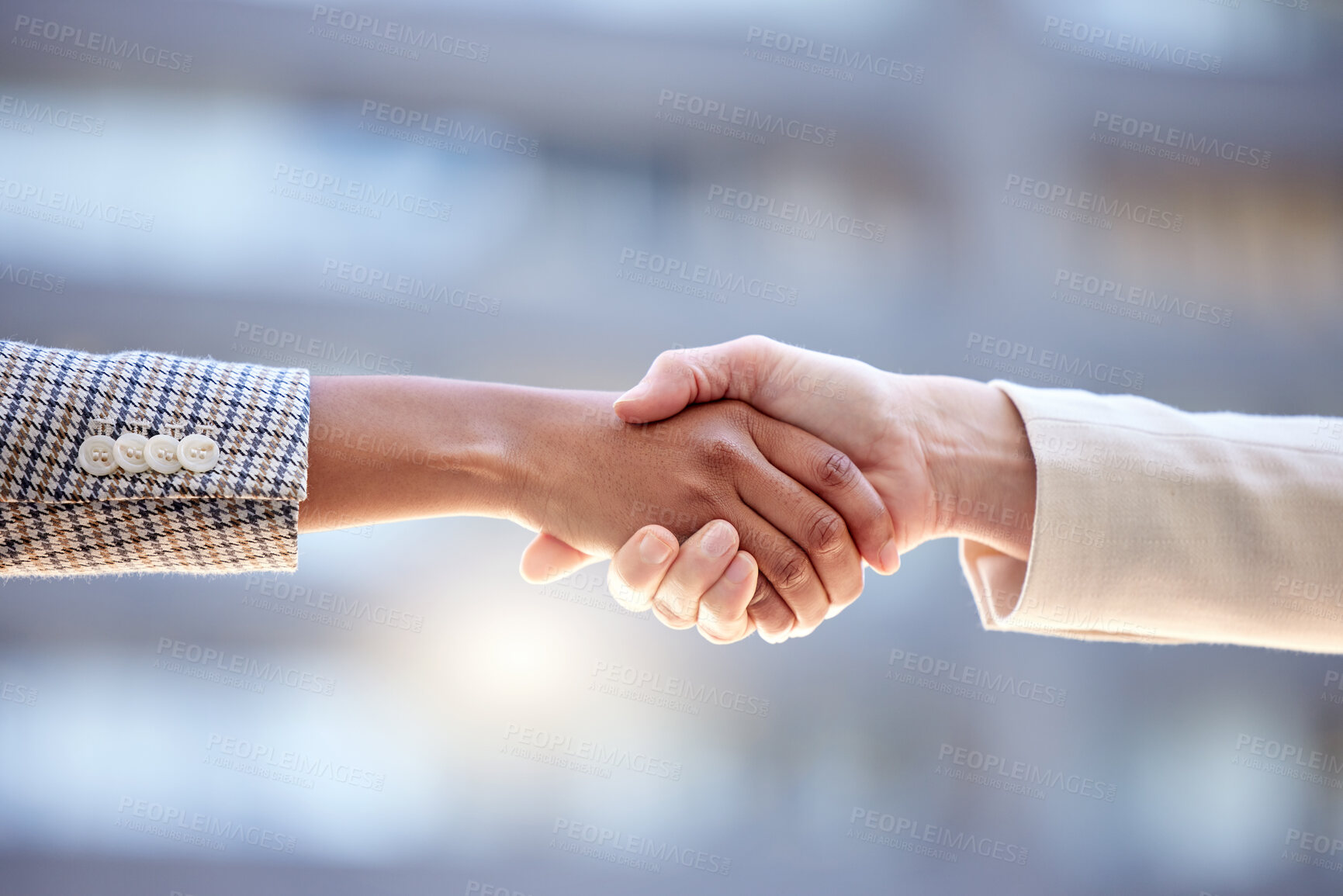 Buy stock photo Shot of two unrecognizable businesspeople shaking hands against a city background