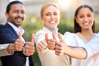 Buy stock photo Shot of a group of businesspeople showing a thumbs up against a city background