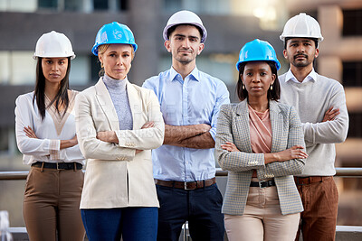 Buy stock photo Shot of a group of architects standing with their arms crossed against a city background