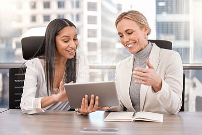 Buy stock photo Shot of two businesswomen planning together while using a digital tablet