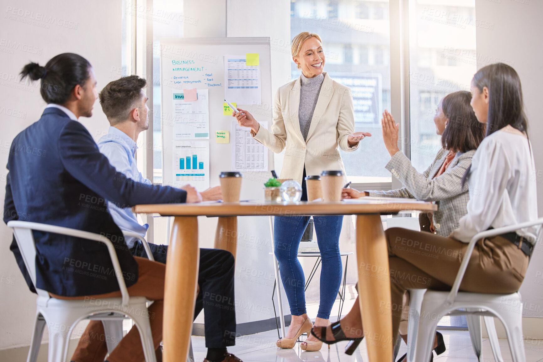 Buy stock photo Shot of a mature businesswoman having a meeting with her colleagues in an office