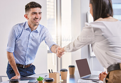 Buy stock photo Shot of a young businessman shaking hands with a colleague in an office