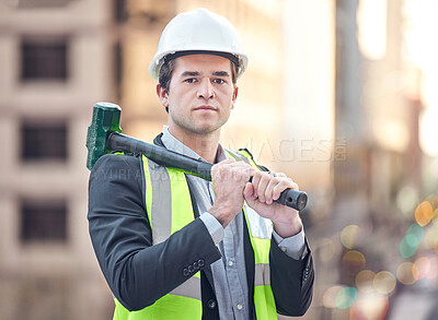 Buy stock photo Cropped portrait of a handsome male construction worker standing with a hammer on a building site