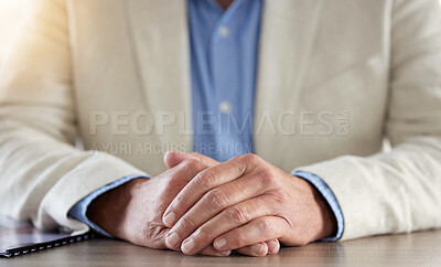 Buy stock photo Cropped shot of an unrecognisable businessman sitting alone in his office with his hands together