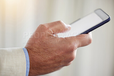 Buy stock photo Cropped shot of an unrecognisable businessman standing alone in the office and using his cellphone