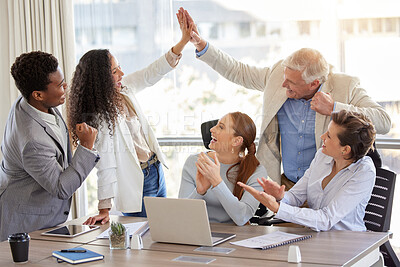 Buy stock photo Shot of a diverse group of businesspeople celebrating a success during a meeting in the office