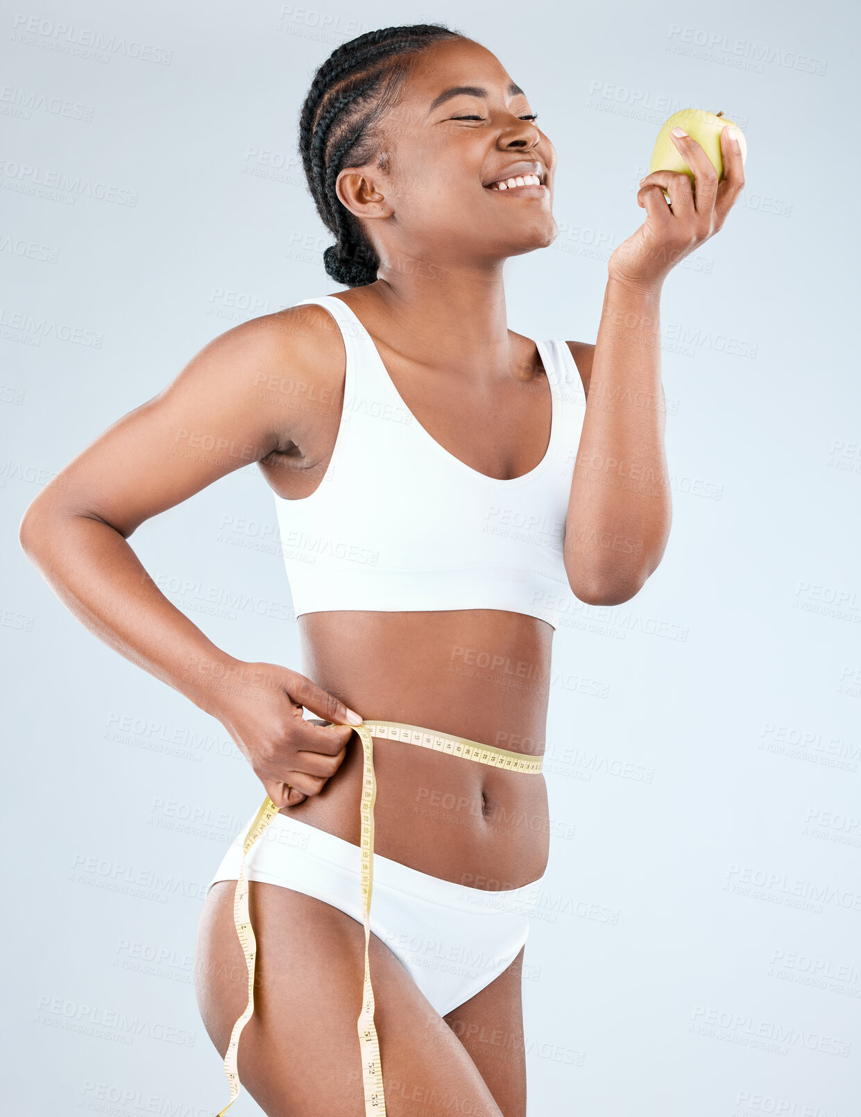 Buy stock photo Woman, body and happy with tape measure in studio on white background with underwear, progress and weight loss. Positivity, fitness and stomach with apple for self care, health and diet or nutrition