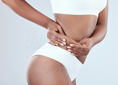 Buy stock photo Shot of a young woman pulling the skin on her waist