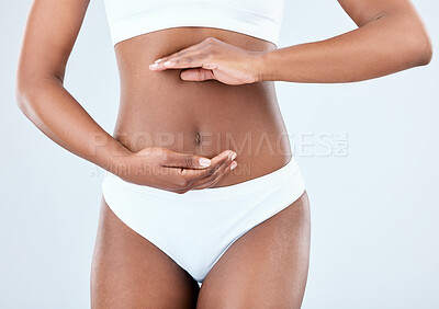 Buy stock photo Hands, black woman and stomach health in studio with underwear, skincare beauty and detox diet for gut wellness. African, female person and body, weight loss and nutrition balance on white background