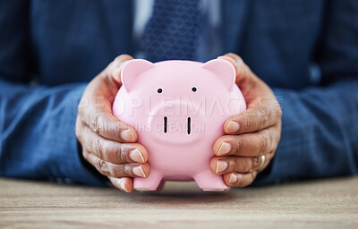 Buy stock photo Shot of a unrecognizable man holding a piggy bank in a office