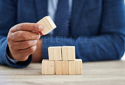 Buy stock photo Shot of an unrecognisable businessman working with wooden building blocks in a modern office
