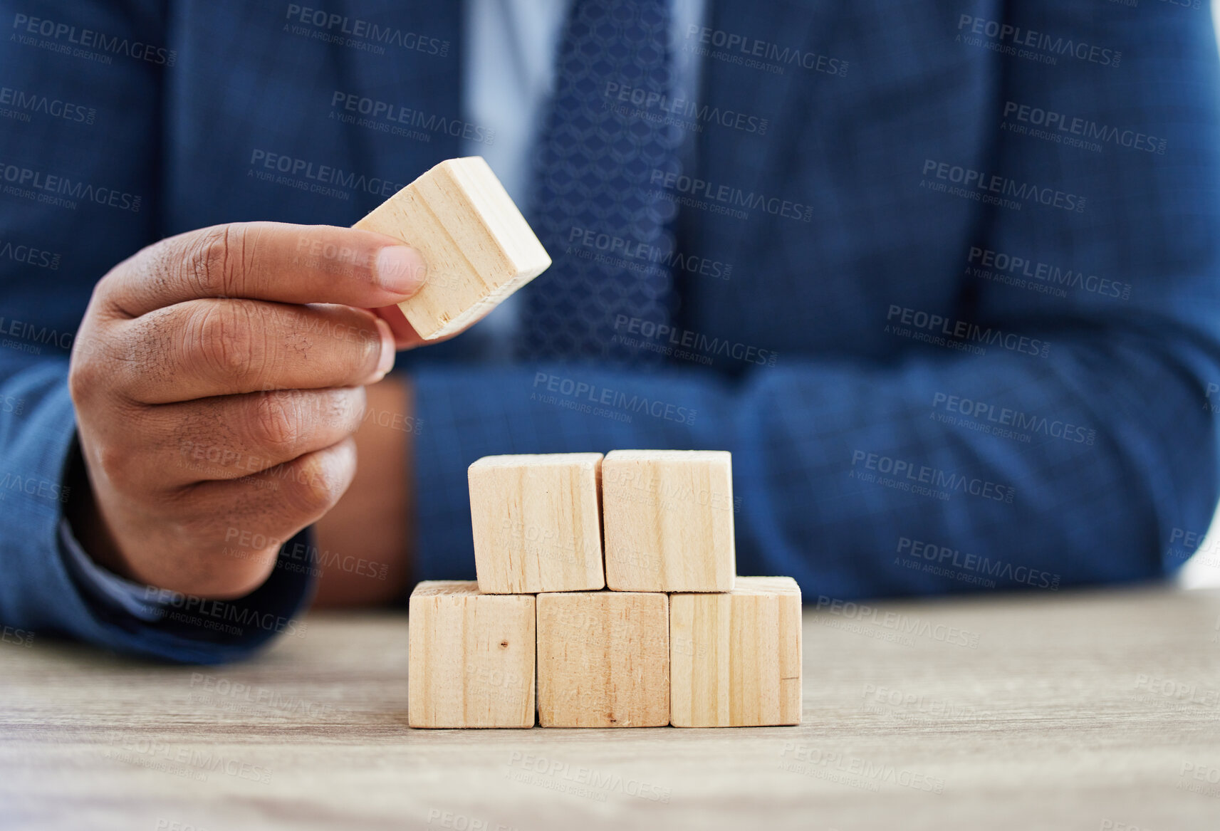 Buy stock photo Building blocks, growth and hand with business person at wooden table in office for corporate planning. Balance, finance and investment with employee stacking pieces at desk for career solution