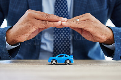 Buy stock photo Shot of a unrecognizable businessman covering a toy car with his hands at home