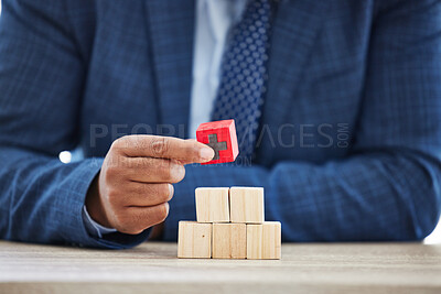 Buy stock photo Shot of an unrecognisable businessman working with wooden building blocks in a modern office