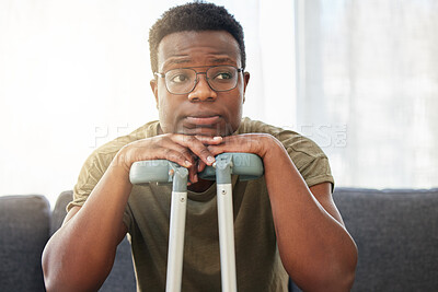 Buy stock photo Shot of a young man using crutches at home