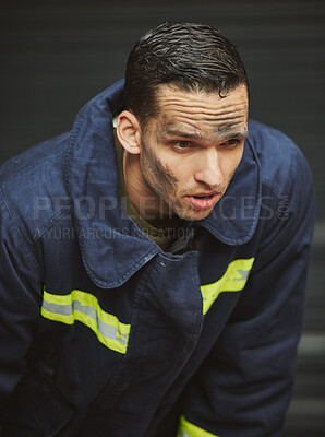 Buy stock photo Shot of a handsome young male firefighter planning his next move