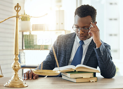 Buy stock photo Shot of a young male lawyer reading a book at work