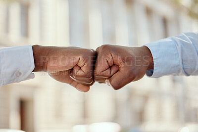 Buy stock photo Shot of two unrecognizable businesspeople giving each other a fist bump in the city