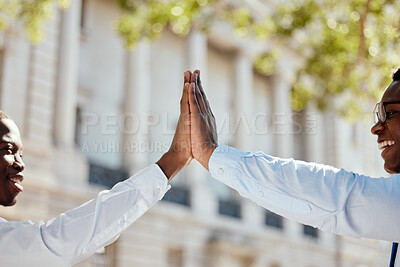 Buy stock photo Shot of a two businesspeople giving each other a high five in the city