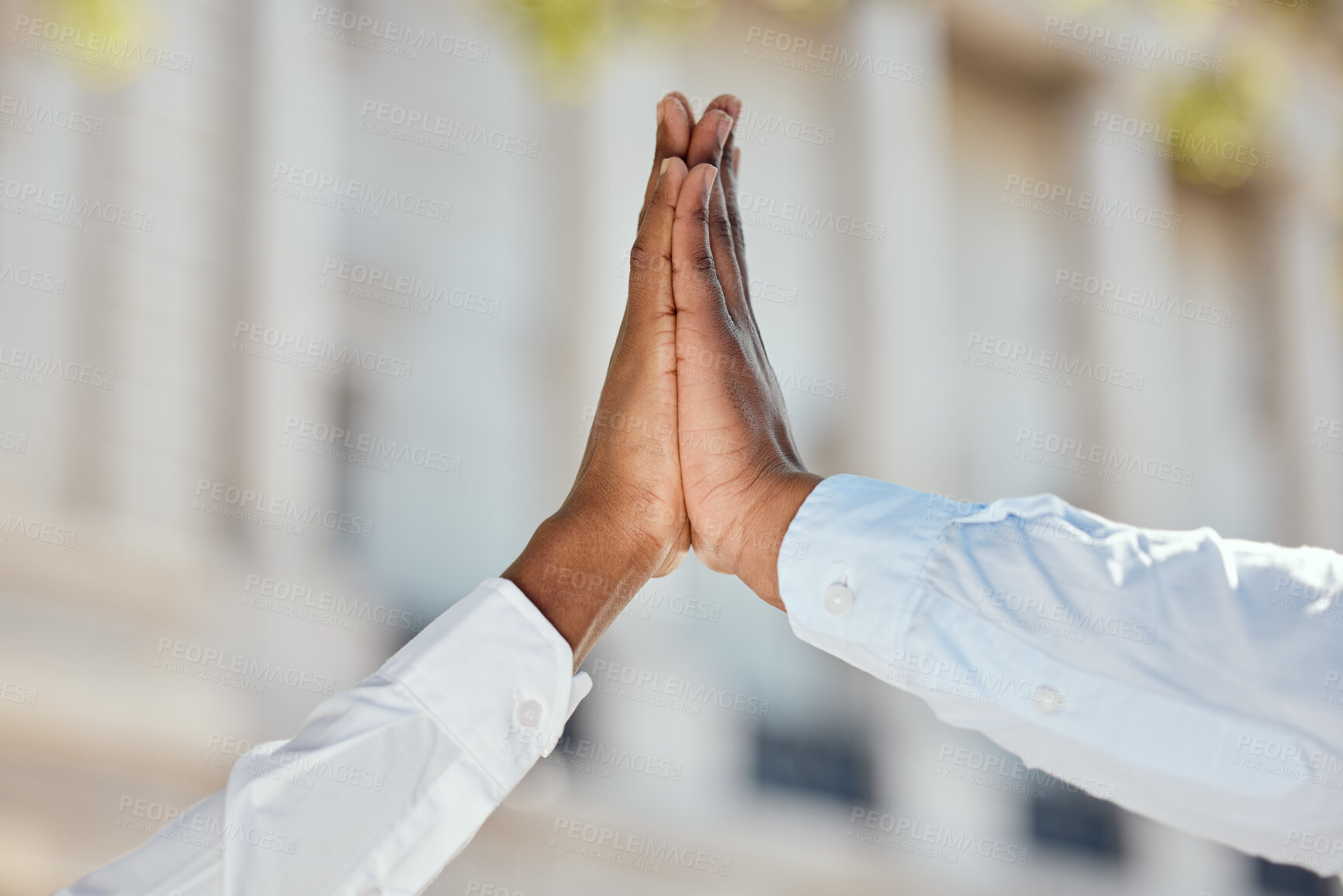 Buy stock photo Shot of a two businesspeople giving each other a high five in the city