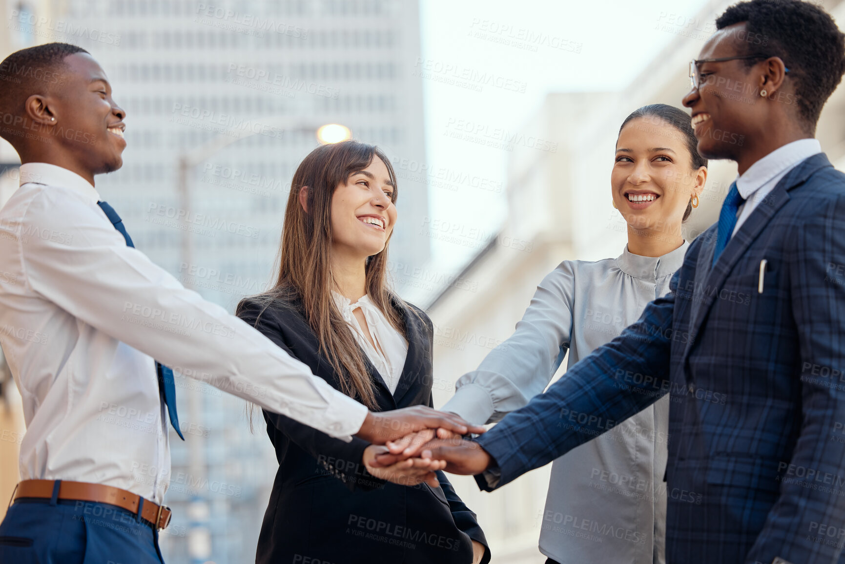 Buy stock photo Shot of a group of young businesspeople stacking their hands in the city