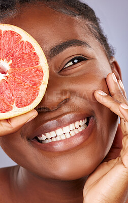 Buy stock photo Black woman, skincare and beauty with grapefruit, product and happy with organic cleanser or results. African, female person and smile for cosmetics, pride or glow for dermatology in gray background
