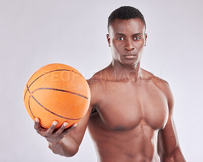 Buy stock photo Studio portrait of a muscular young man posing with a basketball against a grey background