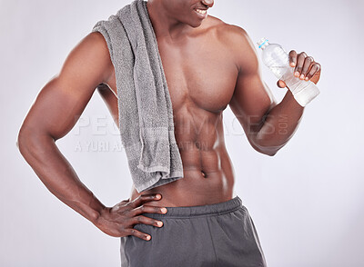 Buy stock photo Studio shot of a muscular young man drinking water against a grey background