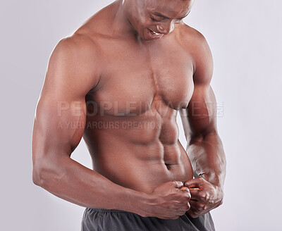 Buy stock photo Studio shot of muscular young man flexing his body against a grey background