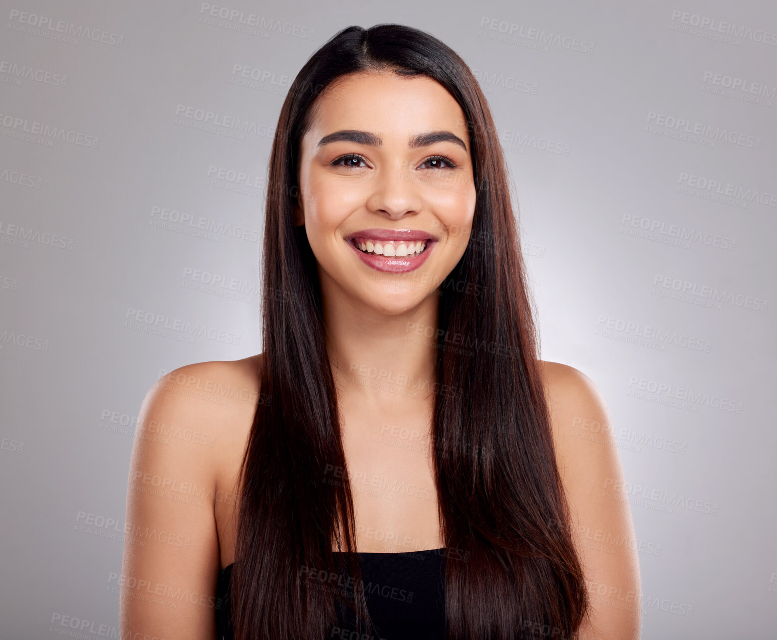 Buy stock photo Studio portrait of an attractive young woman posing against a grey background