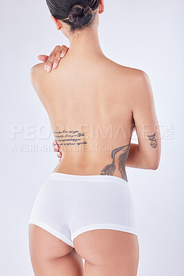 Buy stock photo Rearview shot of a young woman posing against a white background