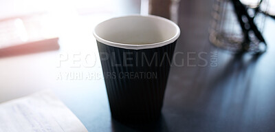 Buy stock photo Shot of a cup on a table in a modern office