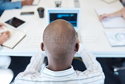 Buy stock photo Shot of a young businessman working on a laptop during a meeting in an office
