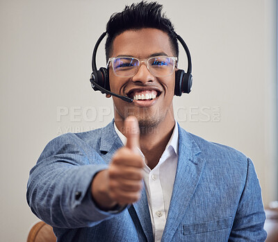 Buy stock photo Portrait of a young call centre agent showing thumbs up while working in an office