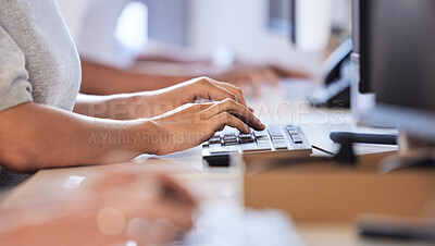Buy stock photo Closeups shot of an unrecognisable businesswoman typing on a computer keyboard while working alongside her colleagues in an office