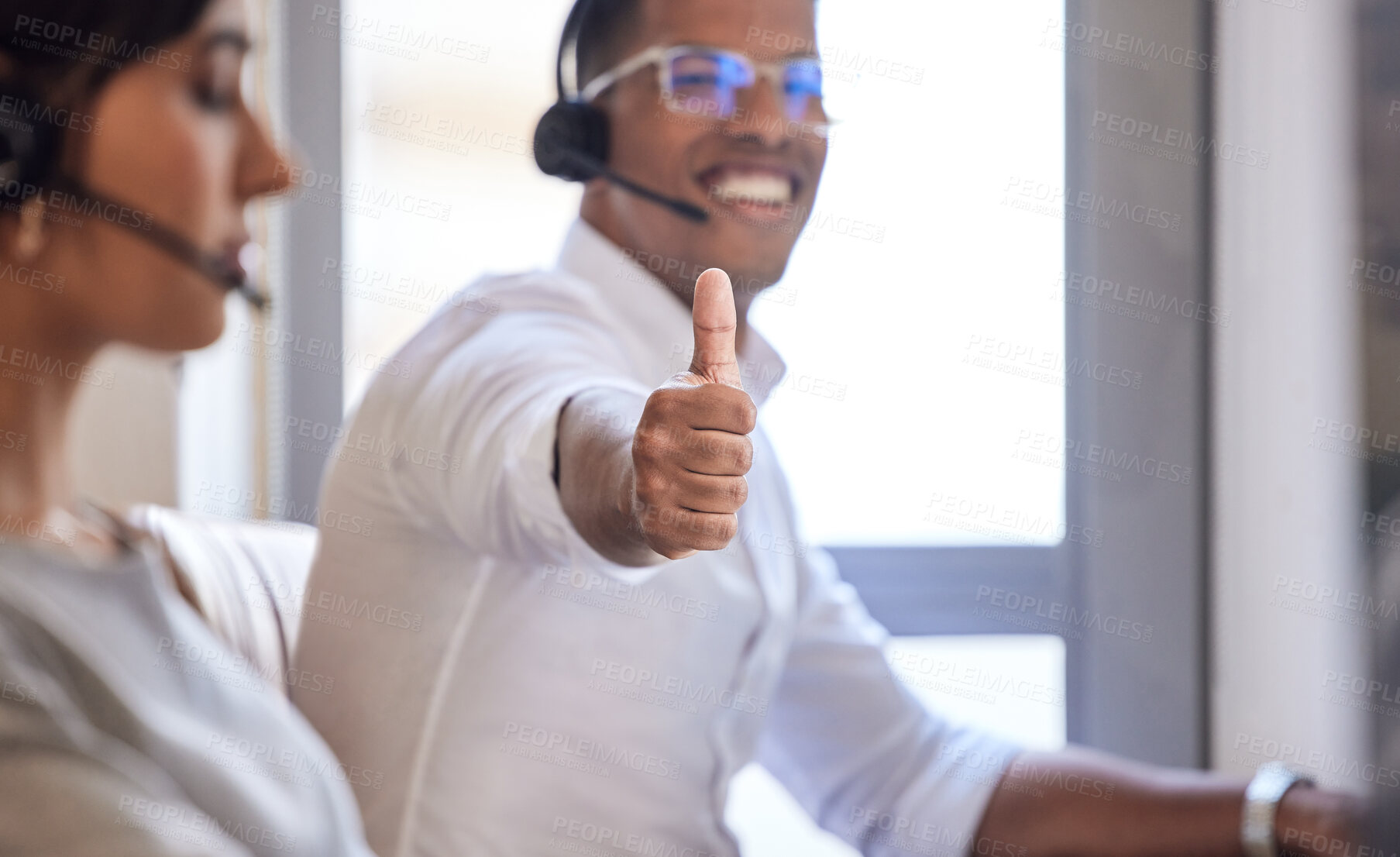 Buy stock photo Closeup shot of a call centre agent showing thumbs up while working in an office