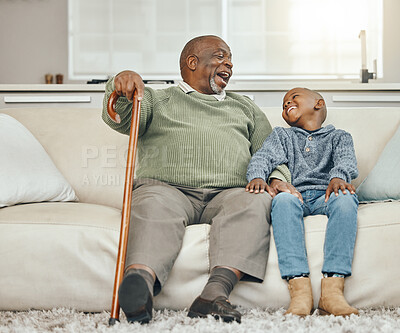 Buy stock photo Shot of a grandfather bonding with his young grandson on a sofa at home