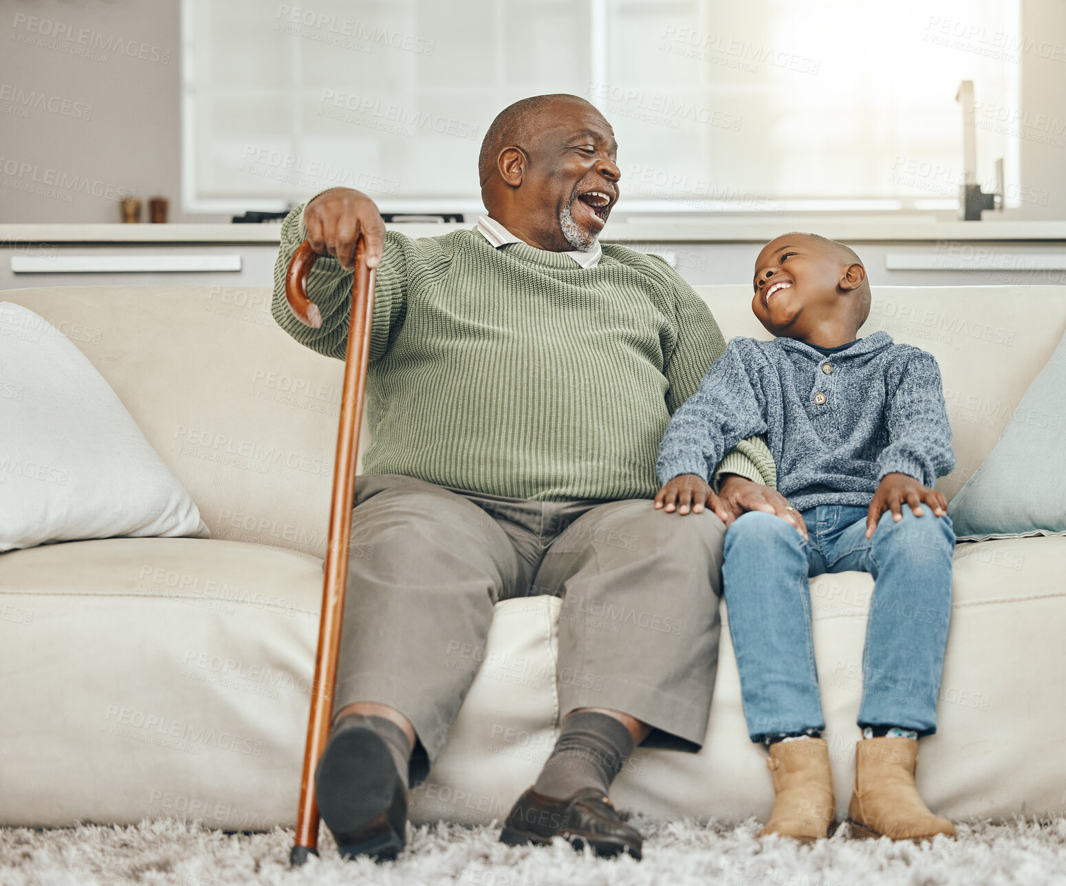 Buy stock photo Shot of a grandfather bonding with his young grandson on a sofa at home