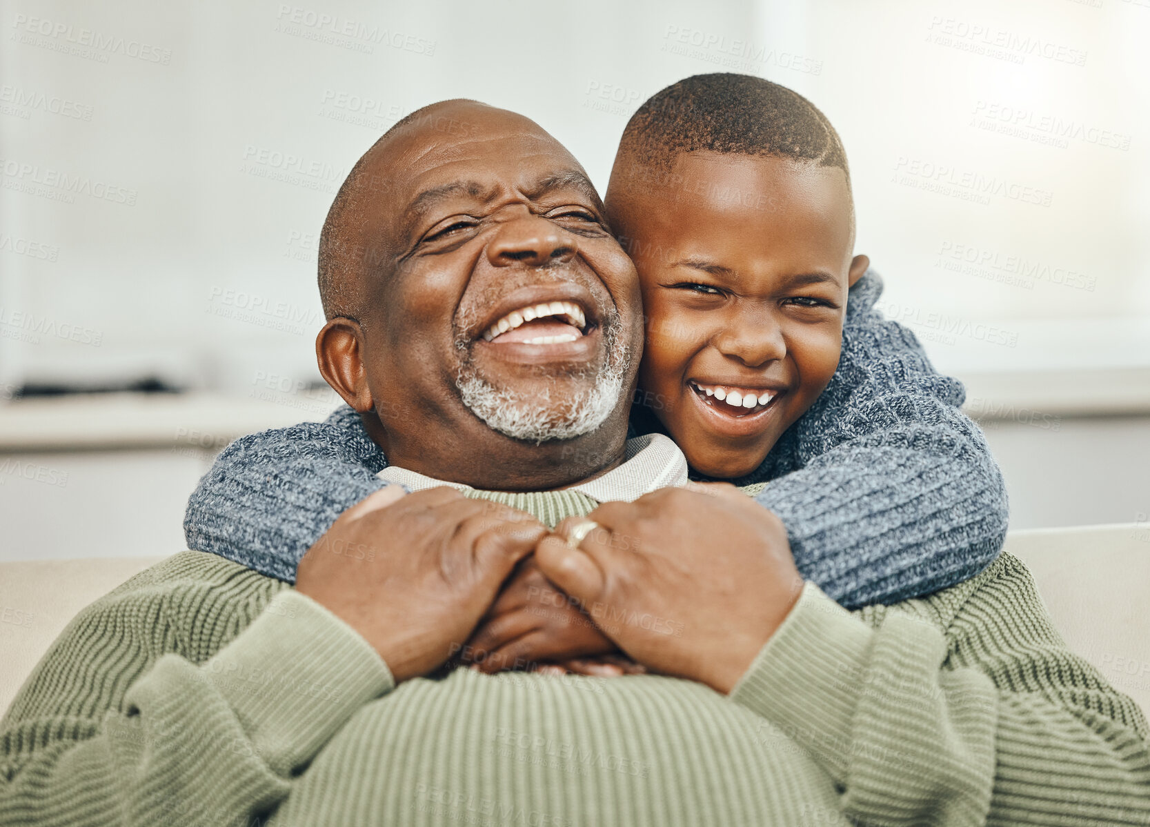 Buy stock photo Shot of a grandfather bonding with his young grandson on a sofa at home