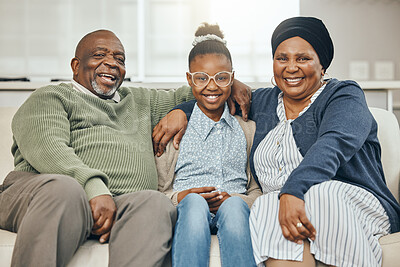 Buy stock photo Shot of two grandparents bonding with their grandchild on a sofa at home