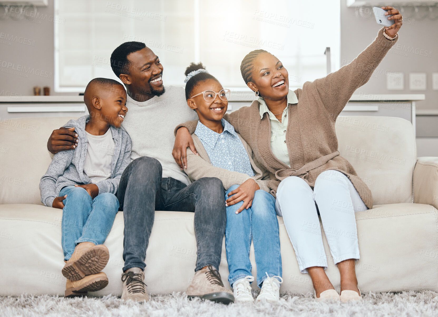 Buy stock photo Shot of a young family taking a selfie together at home