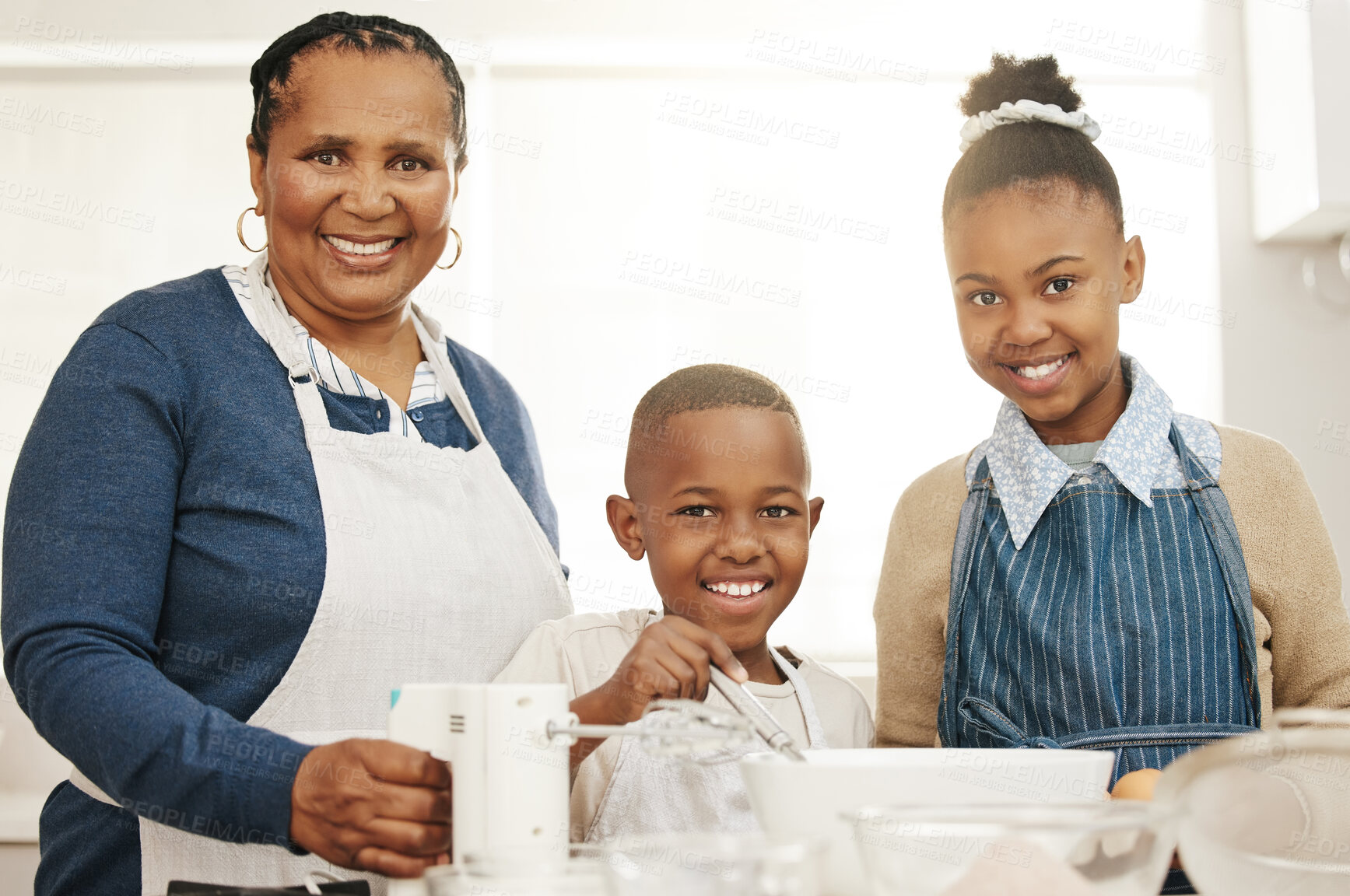 Buy stock photo Shot of a grandmother baking with her two grandkids at home
