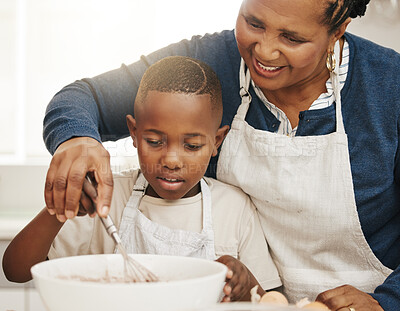 Buy stock photo Shot of a grandmother baking with her grandson at home